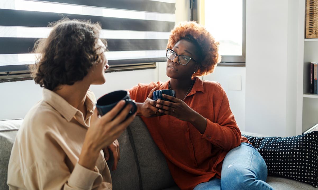 Two women sitting on a couch talking