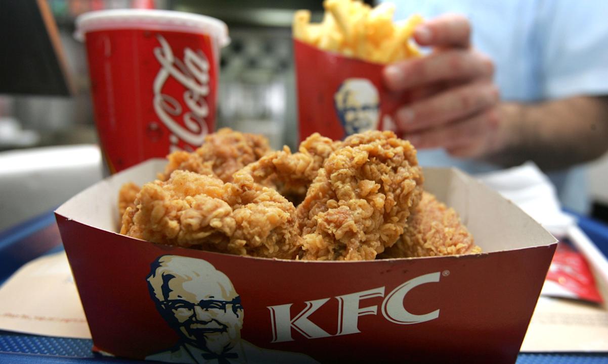 An employee serves a portion of Kentucky Fried Chicken and chips at the international chain's local franchise