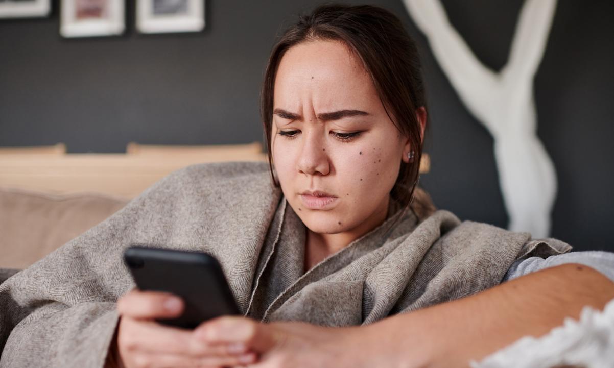 A woman looking at her phone annoyed