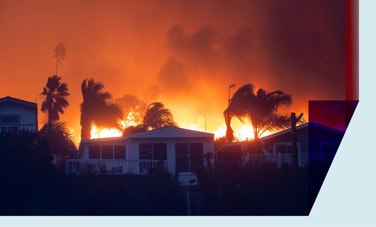 Flames from a brush fire pushed by gusting Santa Ana winds approach homes on January 7, 2025 in Pacific Palisades, Los Angeles, California.